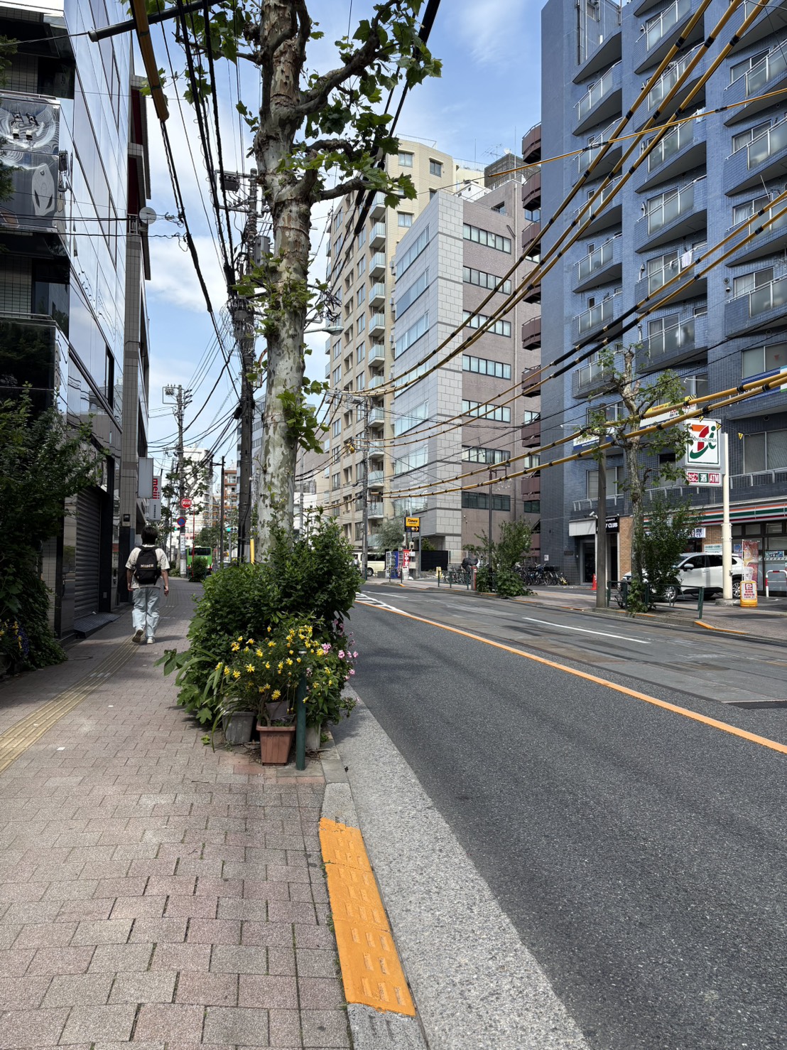 セブンイレブンの向かいに「MEIJI」の看板があるビルが見える