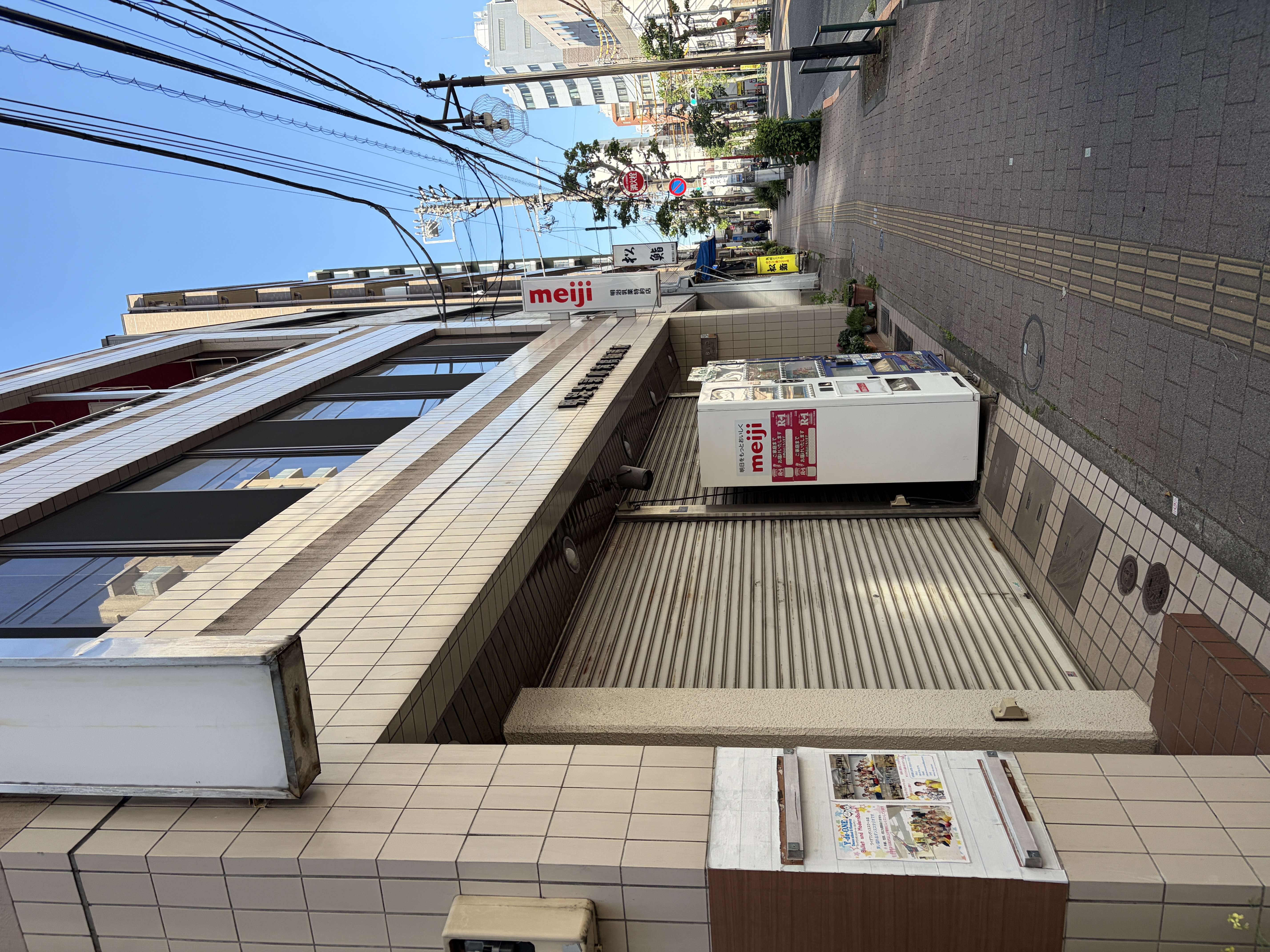 「MEIJI」の看板がある兼子ビル2階にY-de-ONE（ワイデワン）があります
