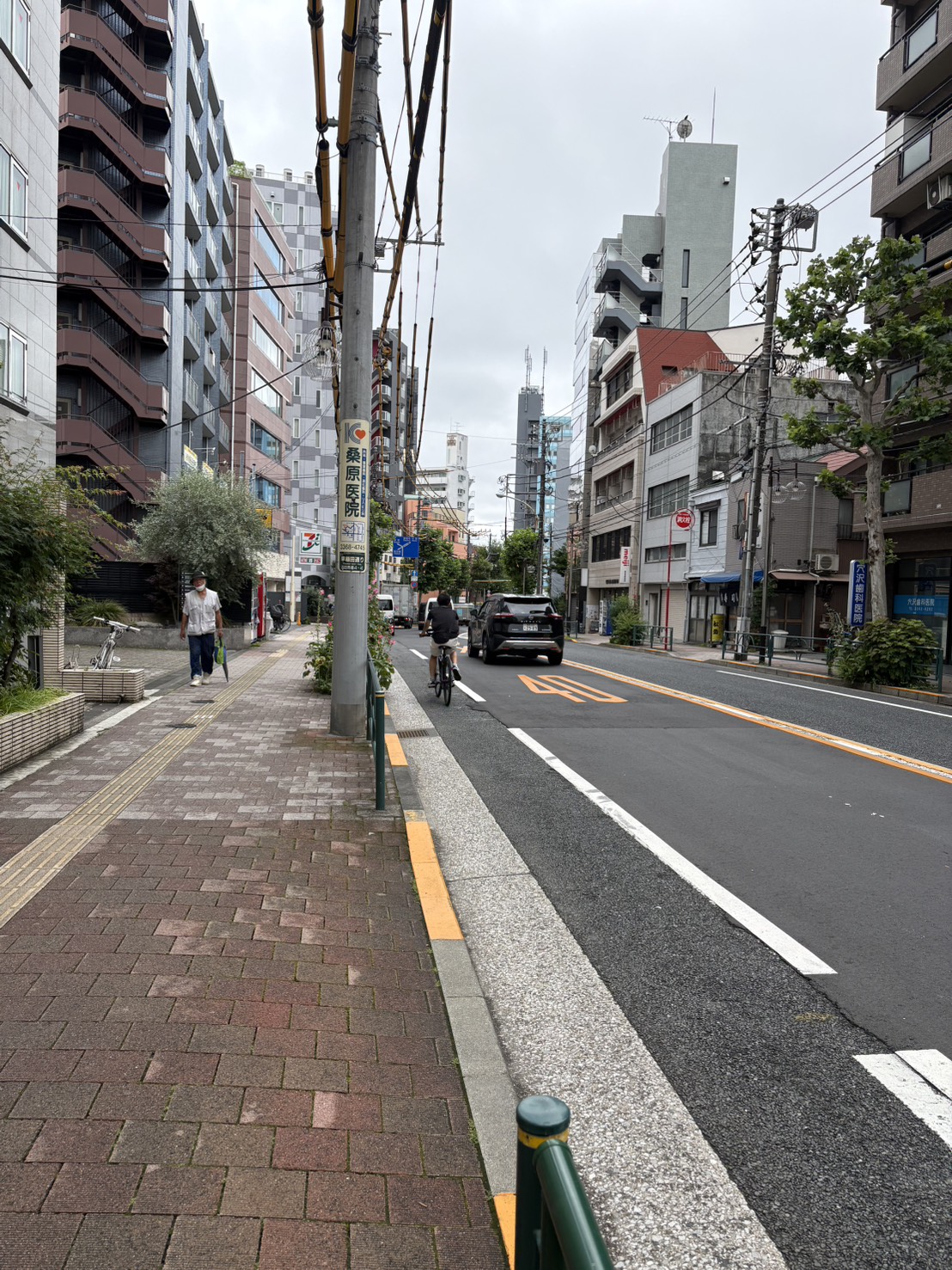 セブンイレブンの向かいに「MEIJI」の看板があるビルが見える
